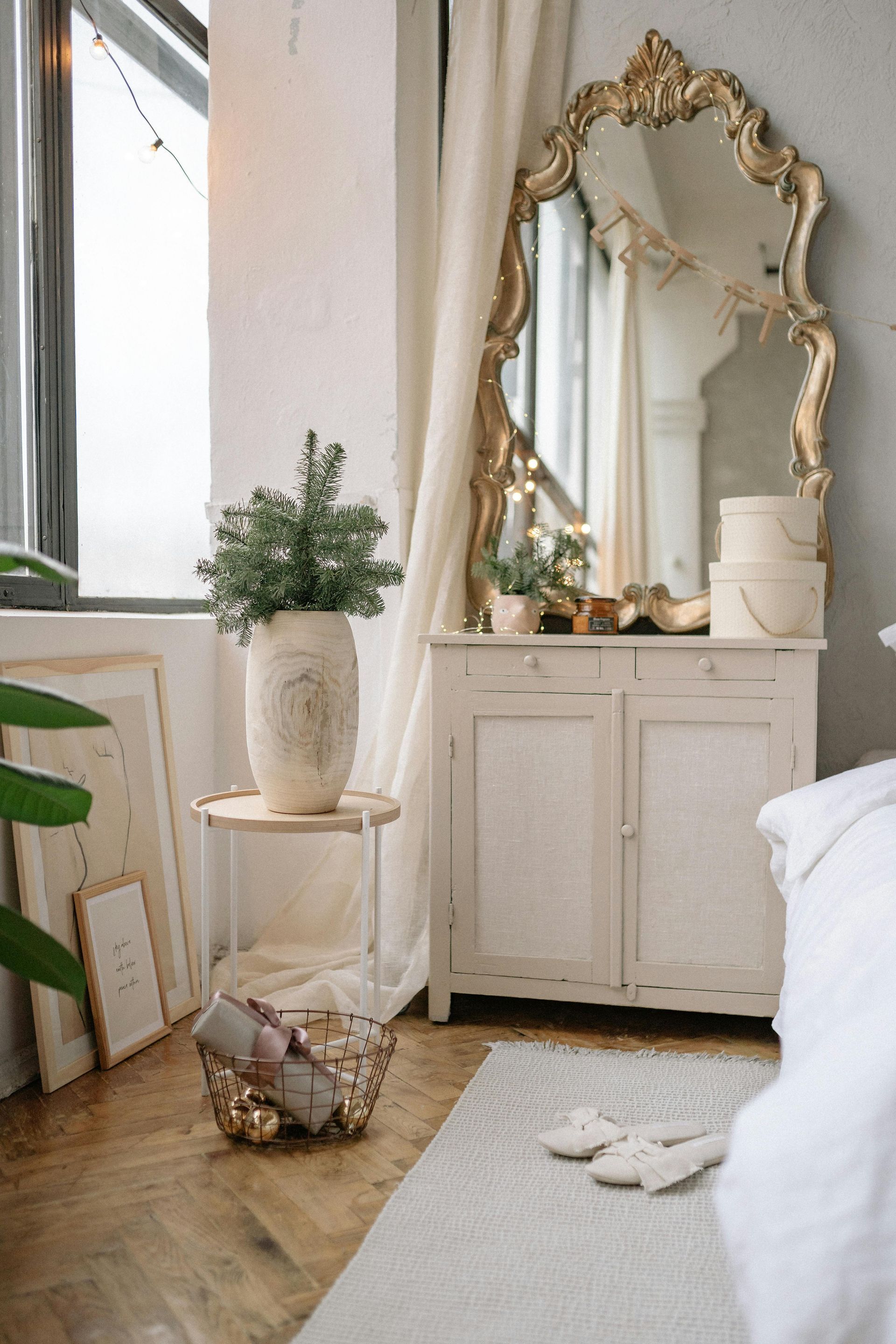 White vintage-style vanity cabinet beneath an ornate gold mirror